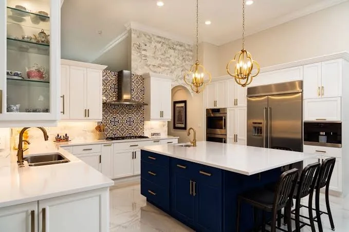 Luxurious kitchen with white cabinets and blue island.